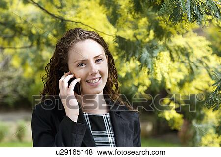 Stock Photo - Close-up of young woman talking on cell phone. Fotosearch
