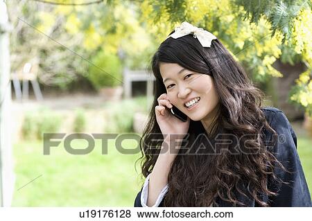 Stock Photo - Close up portrait of young woman talking on mobile phone. Fotosearch