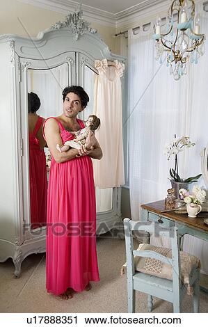 Drag queen wearing nightwear holding doll View Large Photo Image Stock Image - Drag queen wearing nightwear holding doll. Fotosearch