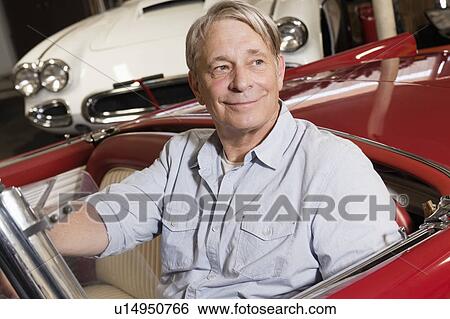 Elderly man smiling in car while looking away View Large Photo Image Stock Photograph - Elderly man smiling in car while looking away. Fotosearch