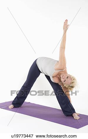 Stock Photo - Full length of a woman bending while exercising. Fotosearch