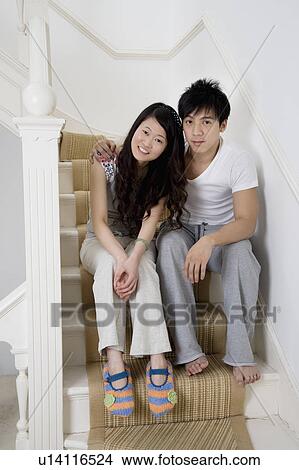 Full length portrait of young couple sitting on staircase View Large Photo Image Picture - Full length portrait of young couple sitting on staircase. Fotosearch