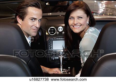 Stock Photo - Happy couple sitting in their new car. Fotosearch