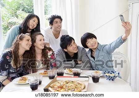 Stock Photo - Happy friends taking photograph. Fotosearch