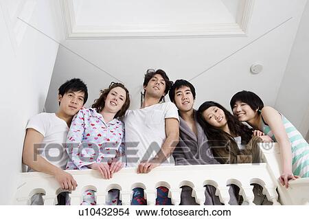Picture - Low angle view of young friends smiling together. Fotosearch