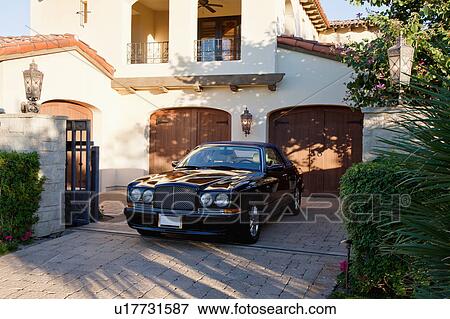 Luxurious car parked in entrance gate of house View Large Photo Image Stock Photo - Luxurious car parked in entrance gate of house. Fotosearch