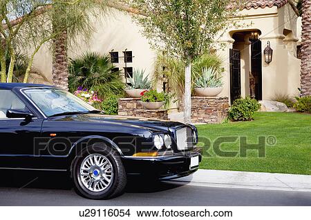 Picture - Luxurious car parked outside a mansion. Fotosearch