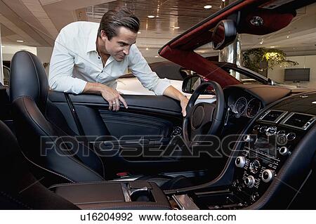 Stock Image - Man checking out his new car. Fotosearch