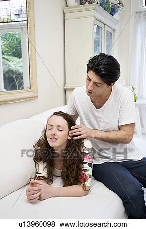 Man giving head massaging to woman on sofa View Large Photo Image Stock Photo - Man giving head massaging to woman on sofa. Fotosearch