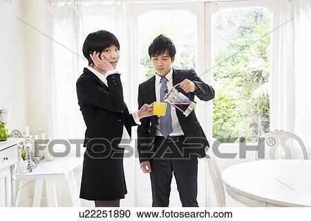 Man pouring ea while woman talking on cell phone View Large Photo Image Stock Image - Man pouring ea while woman talking on cell phone. Fotosearch