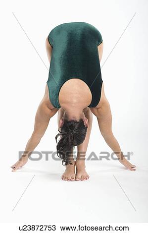 Stock Image - Mid adult woman in yoga position. Fotosearch