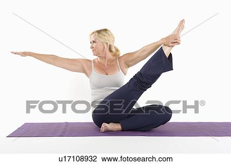 Stock Image - Middle aged woman doing yoga over white background. Fotosearch