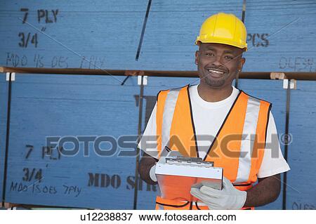 Stock Photo - Portrait of a happy mid-adult man working in warehouse. Fotosearch