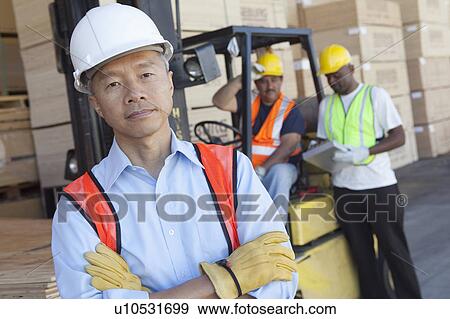 Portrait of a man in front of two workers View Large Photo Image Stock Photo - Portrait of a man in front of two workers. Fotosearch