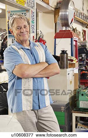 Stock Photo - Portrait of smiling elderly man in automobile workshop. Fotosearch