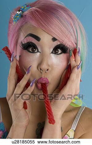 Portrait of young woman holding candy cane in her mouth View Large Photo Image Stock Photography - Portrait of young woman holding candy cane in her mouth. Fotosearch