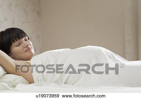 Pregnant woman sleeping on bed View Large Photo Image Stock Photo - Pregnant woman sleeping on bed. Fotosearch