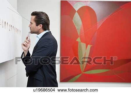 Picture - Profile view of a young man in a art art gallery. Fotosearch