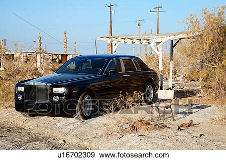 Stock Photo - Rolls Royce parked next to broken chair in abandoned village. Fotosearch