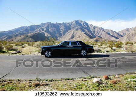 Rolls Royce travelling on country road with mountains in background View Large Photo Image Stock Image - Rolls Royce travelling on country road with mountains in background. Fotosearch