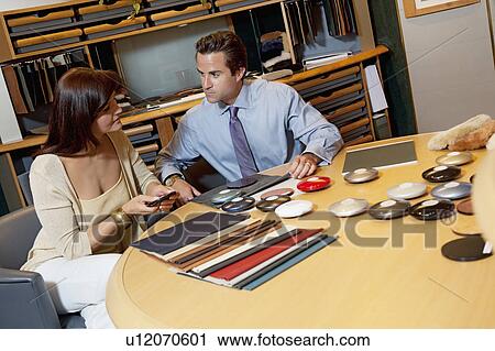 Stock Image - Salesperson showing color samples to female client. Fotosearch