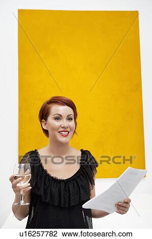 Smiling young woman in front of yellow wall painting View Large Photo Image Stock Image - Smiling young woman in front of yellow wall painting. Fotosearch