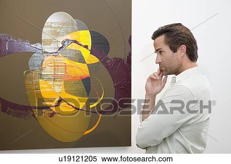 Thoughtful man looking at wall painting in art gallery View Large Photo Image Stock Photography - Thoughtful man looking at wall painting in art gallery. Fotosearch