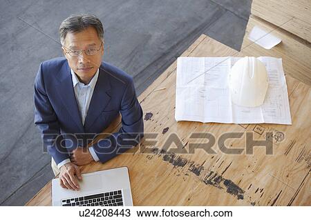 Top view of manager using laptop on plywood in warehouse View Large Photo Image Stock Image - Top view of manager using laptop on plywood in warehouse. Fotosearch