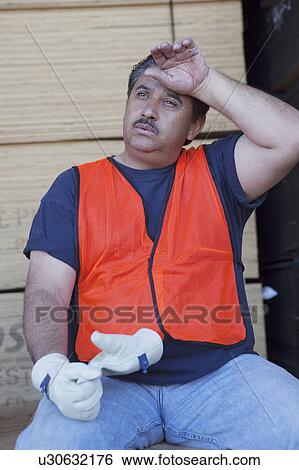 Stock Photograph - Warehouse worker cooling off from work pressure. Fotosearch
