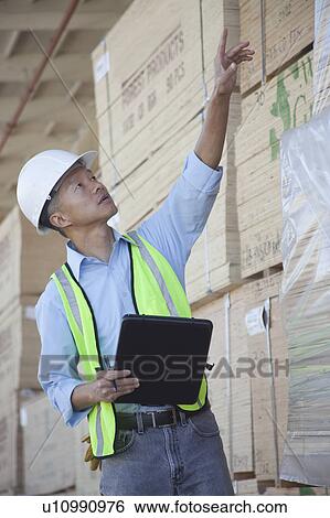 Warehouse worker taking inventory View Large Photo Image Stock Photograph - Warehouse worker taking inventory. Fotosearch