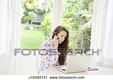 Woman on call while working on laptop View Large Photo Image Stock Image - Woman on call while working on laptop. Fotosearch