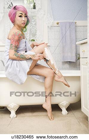 Woman shaving her legs on the side of the bathtub View Large Photo Image Stock Photography - Woman shaving her legs on the side of the bathtub. Fotosearch