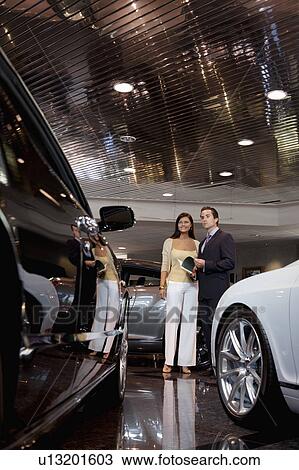 Woman standing with auto salesman in showroom View Large Photo Image Stock Image - Woman standing with auto salesman in showroom. Fotosearch