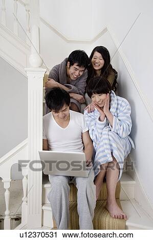 Young couples enjoying while using laptop View Large Photo Image Stock Image - Young couples enjoying while using laptop. Fotosearch