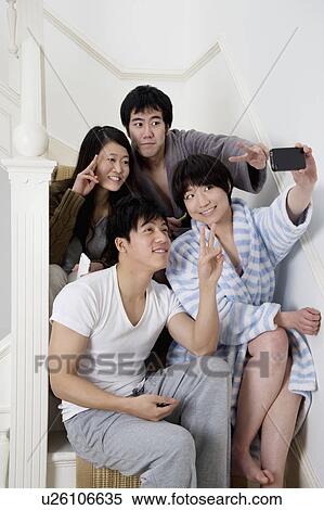 Young friends gesturing peace sign while taking self photograph View Large Photo Image Stock Photography - Young friends gesturing peace sign while taking self photograph. Fotosearch