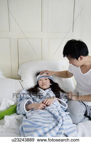 Young man taking care of sick woman in bed View Large Photo Image Stock Photo - Young man taking care of sick woman in bed. Fotosearch
