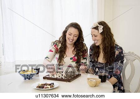 Young sisters playing a game of chess View Large Photo Image Picture - Young sisters playing a game of chess. Fotosearch