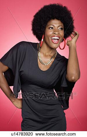 Stock Image - Young woman dancing over colored background. Fotosearch