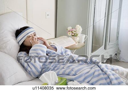 Young woman lying on bed with common cold View Large Photo Image Stock Photography - Young woman lying on bed with common cold. Fotosearch