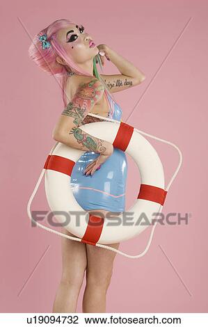 Young woman posing with float tube over pink background View Large Photo Image Stock Image - Young woman posing with float tube over pink background. Fotosearch