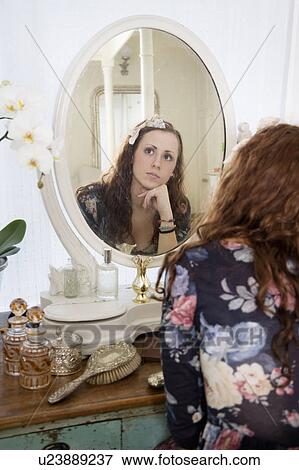 Stock Photo - Young woman thinking in front of mirror. Fotosearch