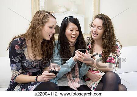 Young women sharing video on cell phone View Large Photo Image Stock Image - Young women sharing video on cell phone. Fotosearch