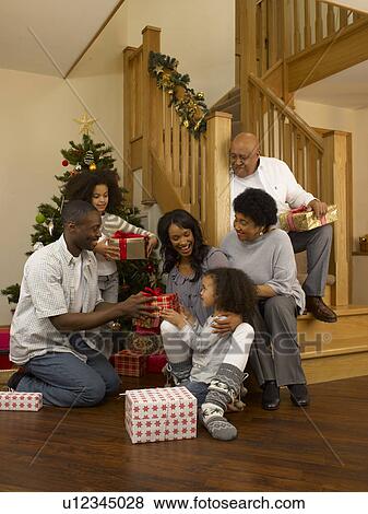 Stock Photo - African American family exchanging Christmas gifts. Fotosearch