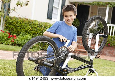 boy fixing bike in garden View Large Photo Image Stock Image - boy fixing bike in garden. Fotosearch