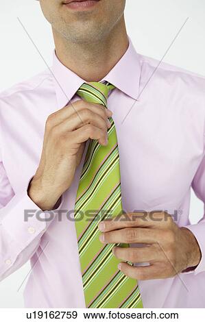 Buisnessman straightening tie View Large Photo Image Stock Photo - Buisnessman straightening tie. Fotosearch
