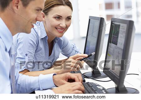 Businessman and woman working on computers View Large Photo Image Stock Image - Businessman and woman working on computers. Fotosearch