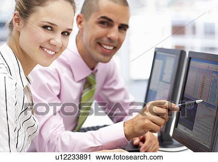 Businessman and woman working on computers View Large Photo Image Stock Image - Businessman and woman working on computers. Fotosearch