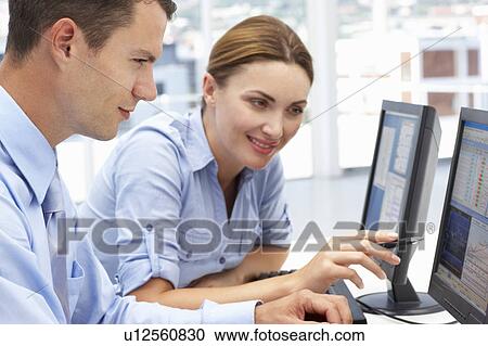 Businessman and woman working on computers View Large Photo Image Stock Image - Businessman and woman working on computers. Fotosearch