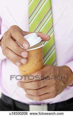 Businessman holding takeout coffee View Large Photo Image Stock Photo - Businessman holding takeout coffee. Fotosearch