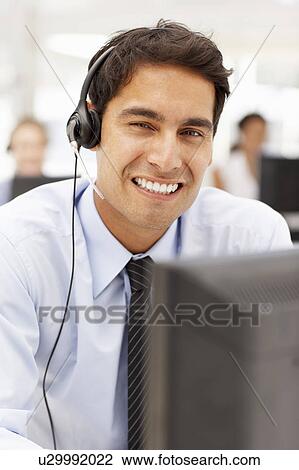 Stock Image - Businessman wearing headset. Fotosearch